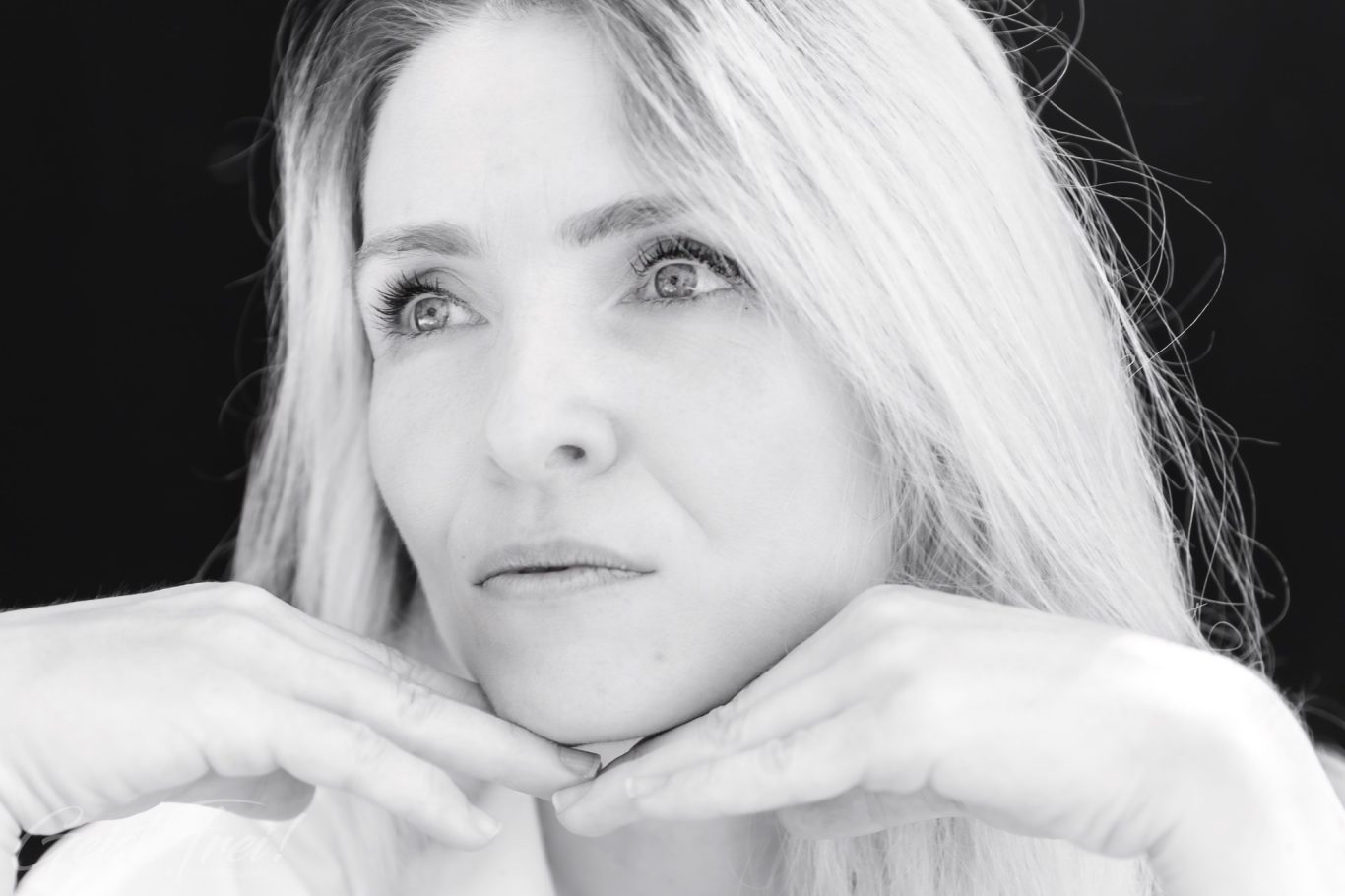 Porträt einer Frau Porträt einer Frau mit langen blonden Haaren, sanfter Ausdruck und nachdenklicher Pose.