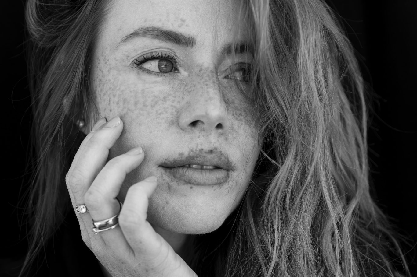 einfach du Porträt einer Frau mit Sommersprossen und langen, gewellten Haaren.