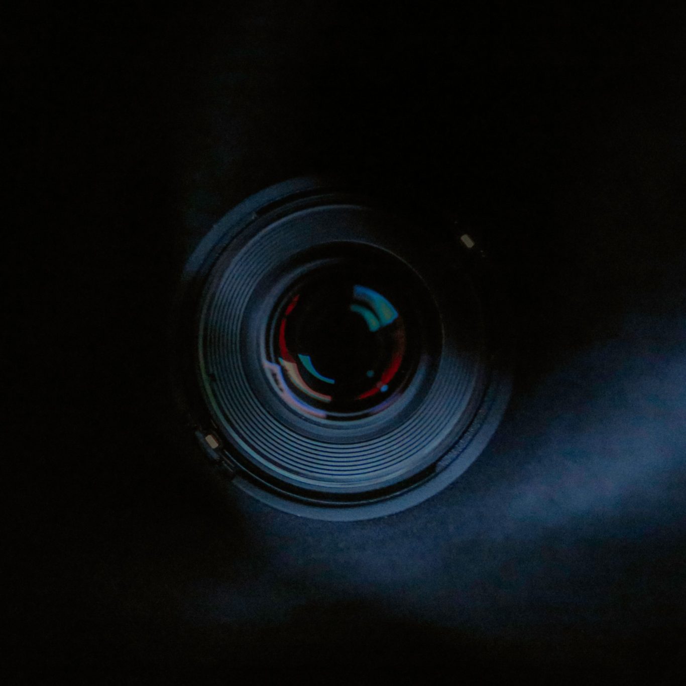 Objekt Kameraobjektiv in dunklem Hintergrund, mit reflektierenden Lichtern.