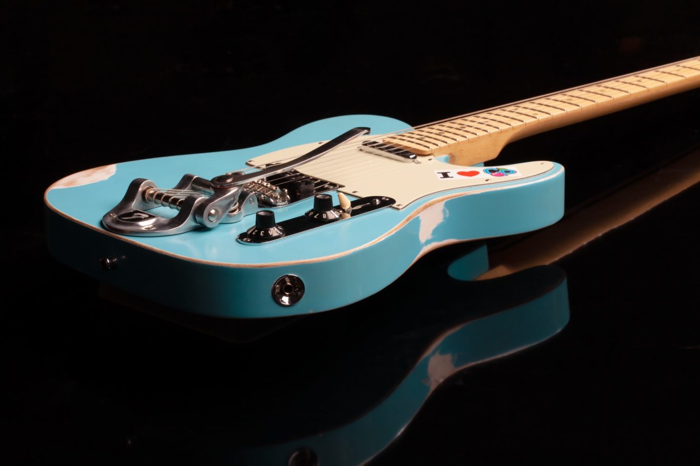 Gitarre Eine hellblaue E-Gitarre mit einem weißen Schlagbrett und schwarzen Details.