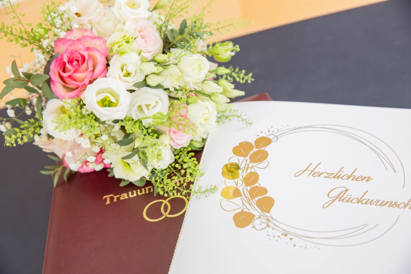 Trauung Standesamt hochzeitsfotografie GeistFrei! Ein Blumenstrauß mit Rosa- und weißen Blüten neben einem eleganten Dokument.