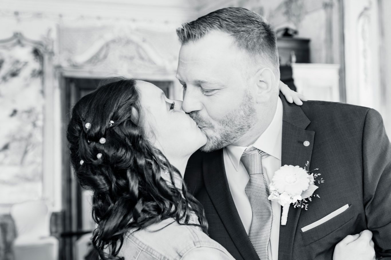 hochzeitsshooting, hochzeitsfotgrafie, wedding, trauung GeistFrei Hochzeitsfoto eines Paares, das sich küssend in einem eleganten Raum umarmt.